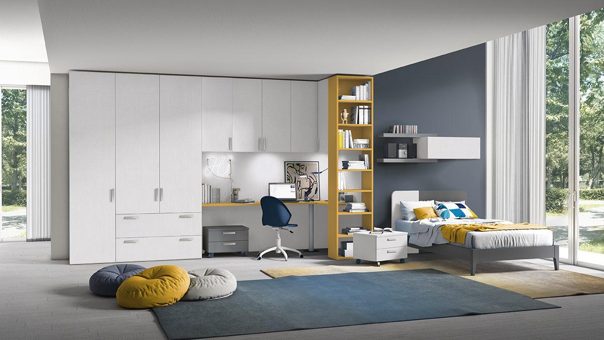 Cameretta con parete attrezzata bianca (armadio, scrivania a incasso e colonna libreria gialla) per ottimizzare lo spazio, letto singolo su parete blu notte, collezione Golf Young's space