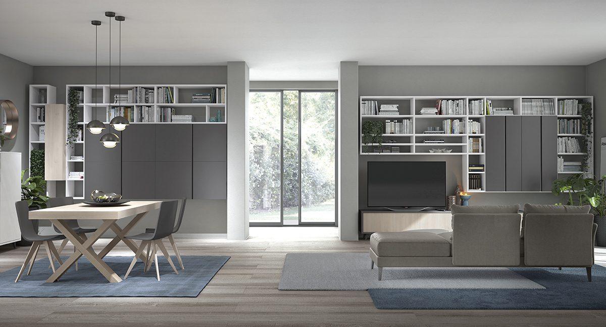 Open space con zona pranzo in legno chiaro, doppia libreria bianca e antracite e divano grigio ad angolo