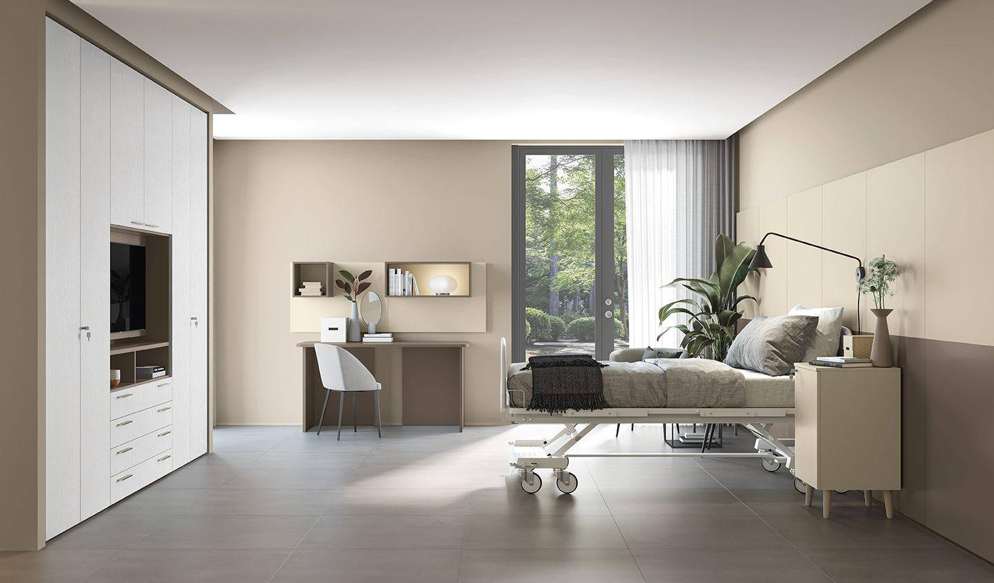 Camera per residenza assistenziale con letto attrezzato, armadio bianco con TV a incasso e scrivania con specchio