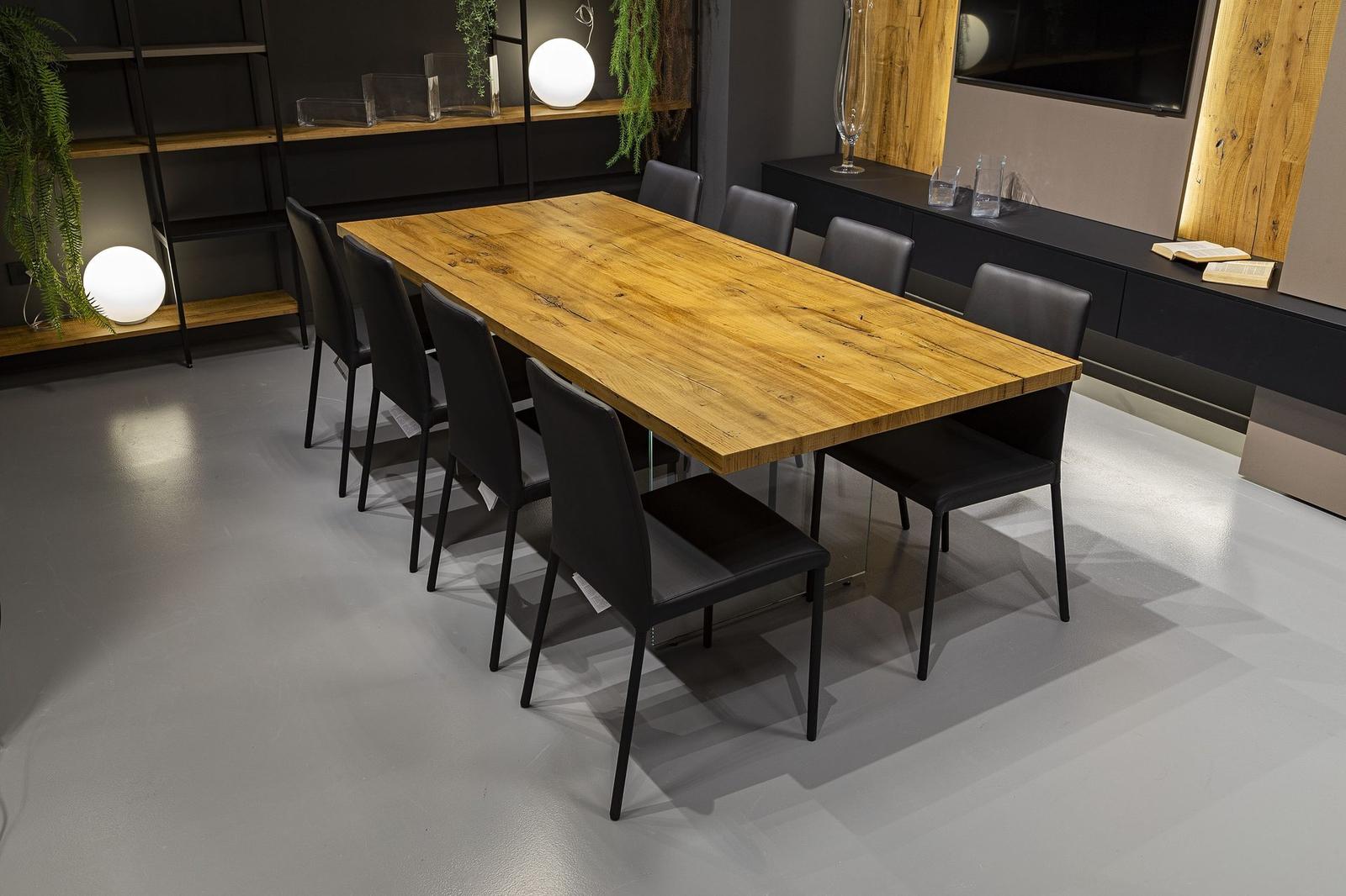 Sala da pranzo con tavolo in legno massello e sedute nere