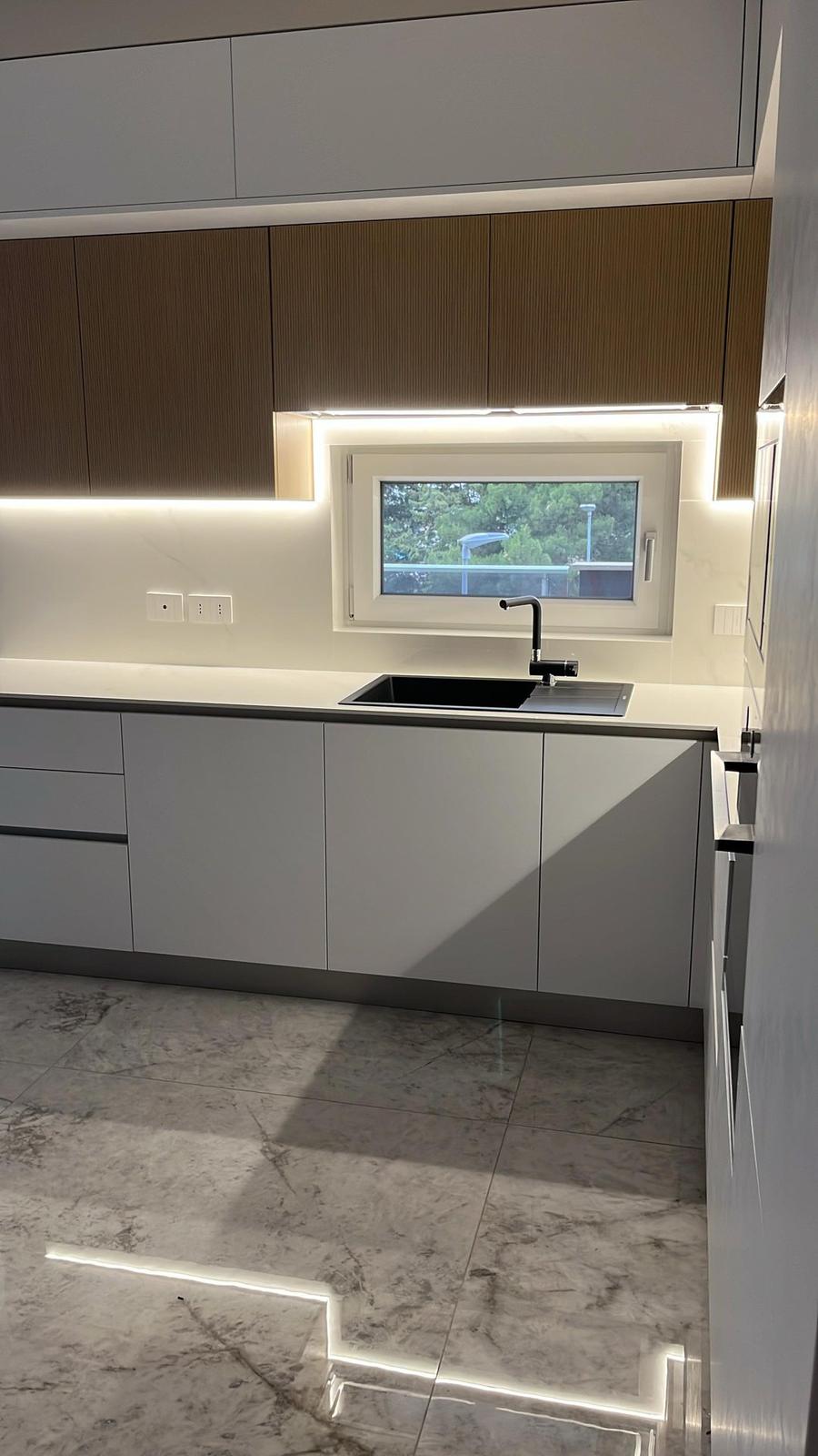 Cucina moderna vista d'insieme con isola e sgabelli