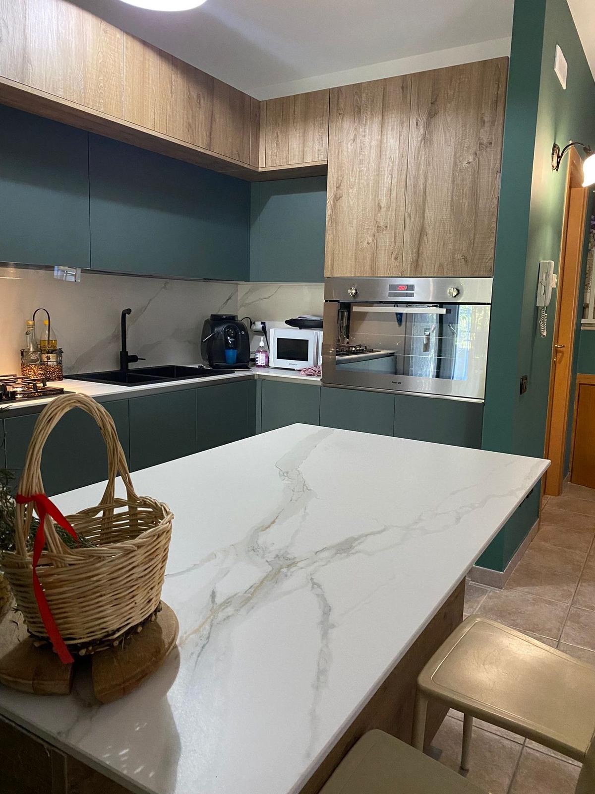 Cucina ad angolo verde petrolio e legno con isola centrale in marmo, realizzazione Barone Arredamenti