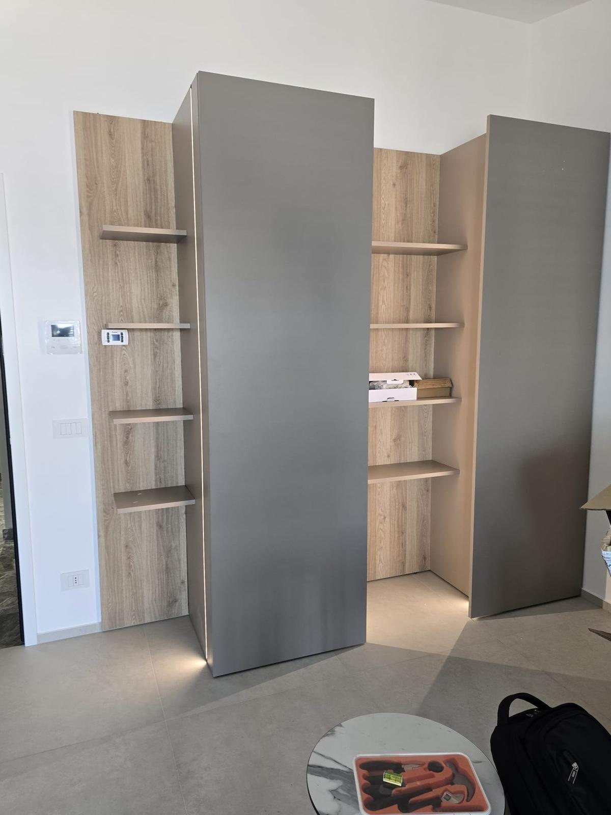 Cabina armadio ad angolo con mensole in legno e illuminazione integrata