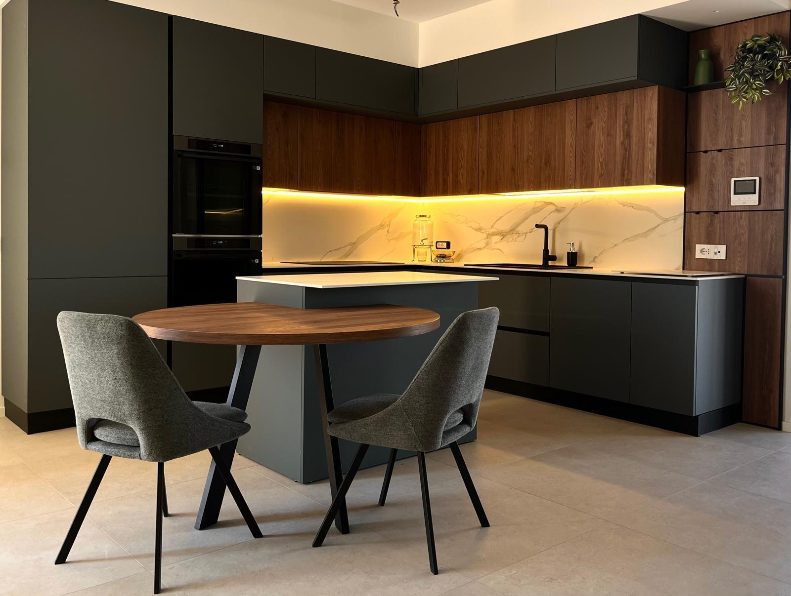 Cucina verde scuro e legno con isola, retroilluminazione a LED e tavolo rotondo